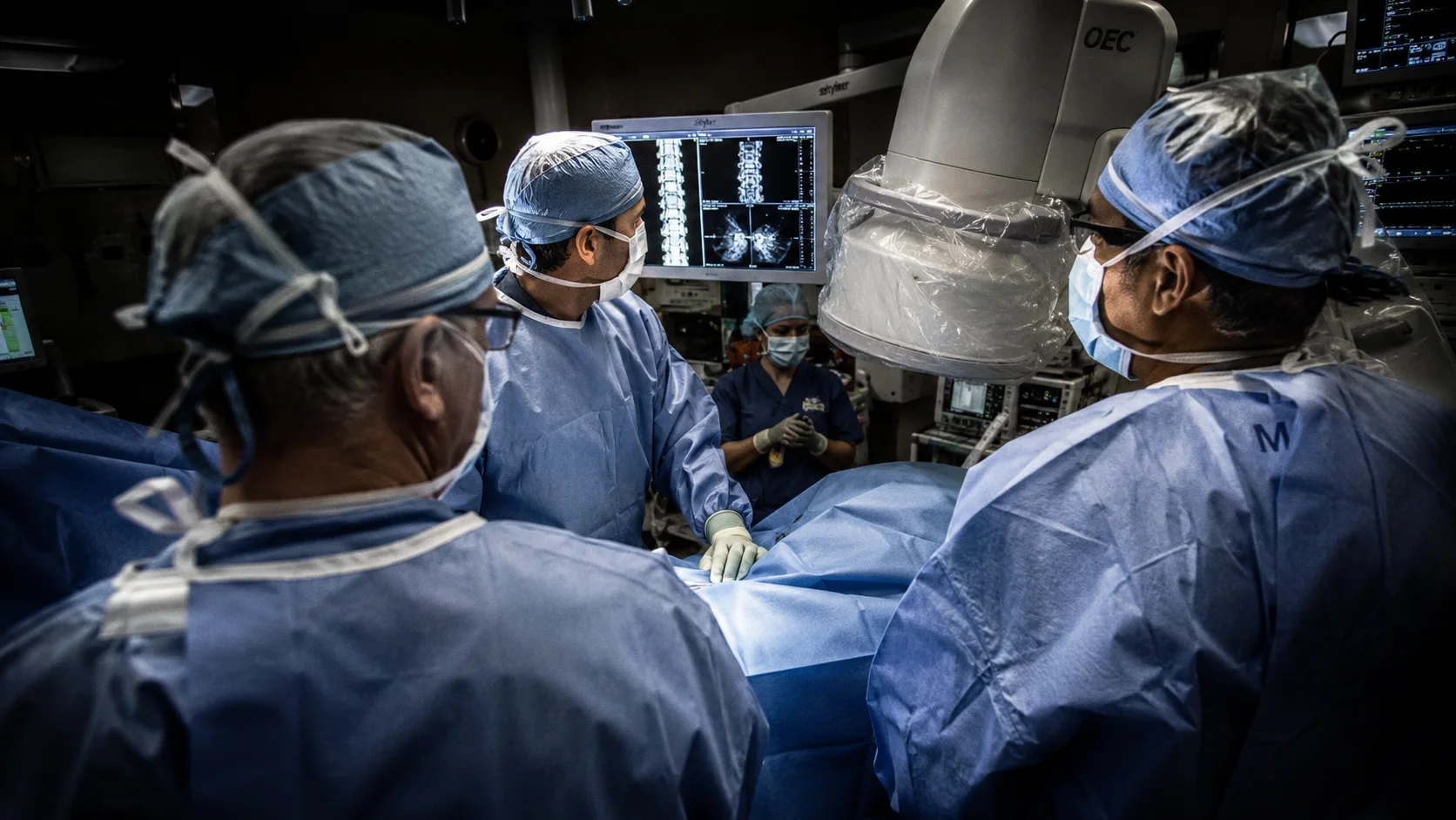 Spine surgical team reviewing intraoperative imaging during a procedure